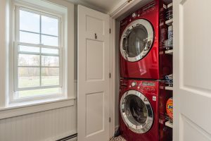red laundry machines stacked in closet