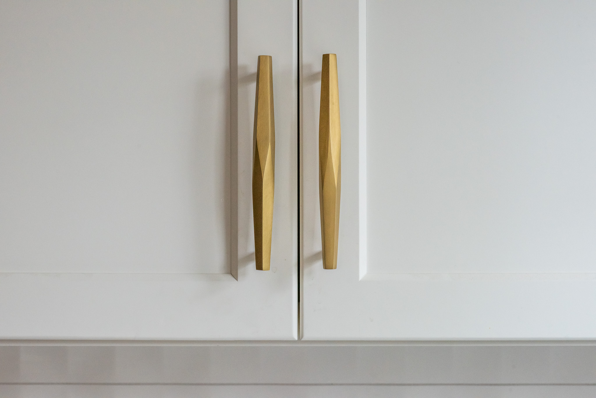 close up of kitchen cabinet wit gold handles