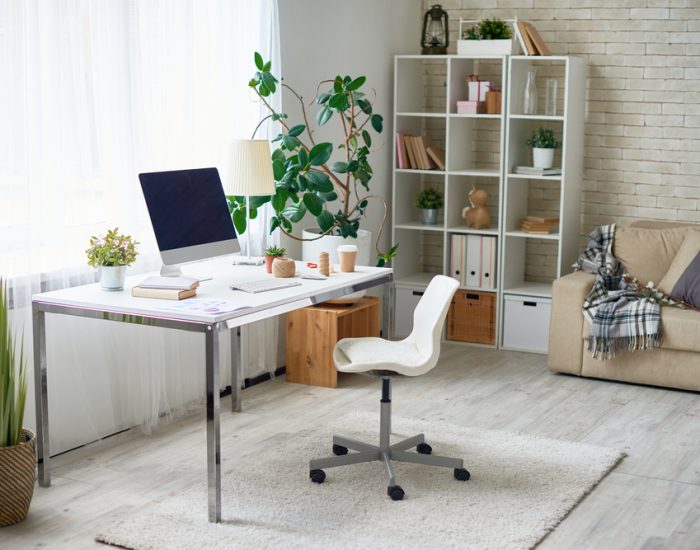 white desk with laptop on it and a white rolling chair for working