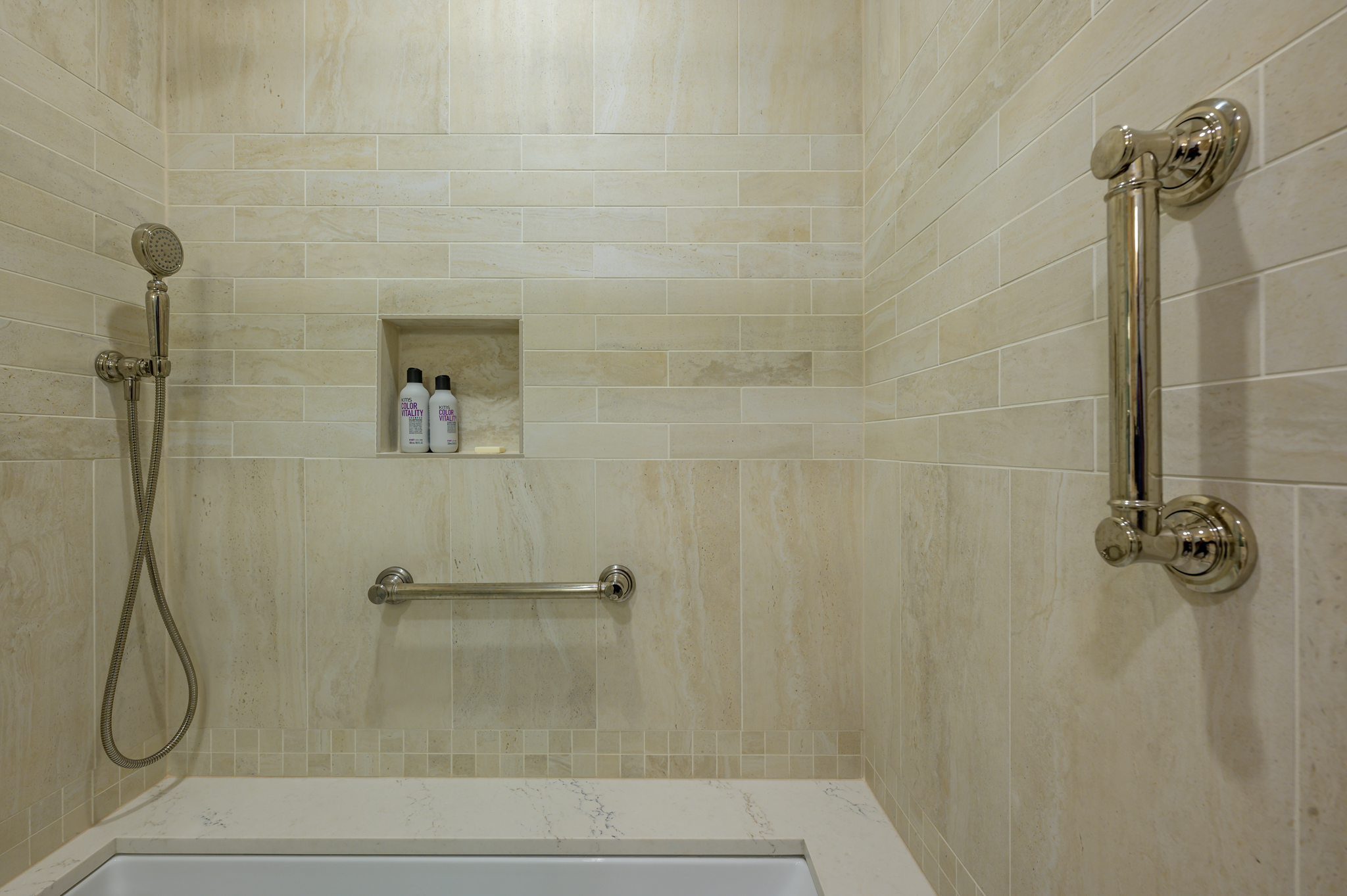 tan tile shower/bathtub with stainless steel faucet and handles