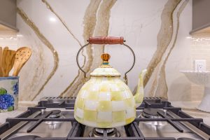 close up of shiny tea kettle with white and yellow checkered pattern