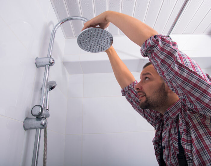 man replacing his own shower head on a budget