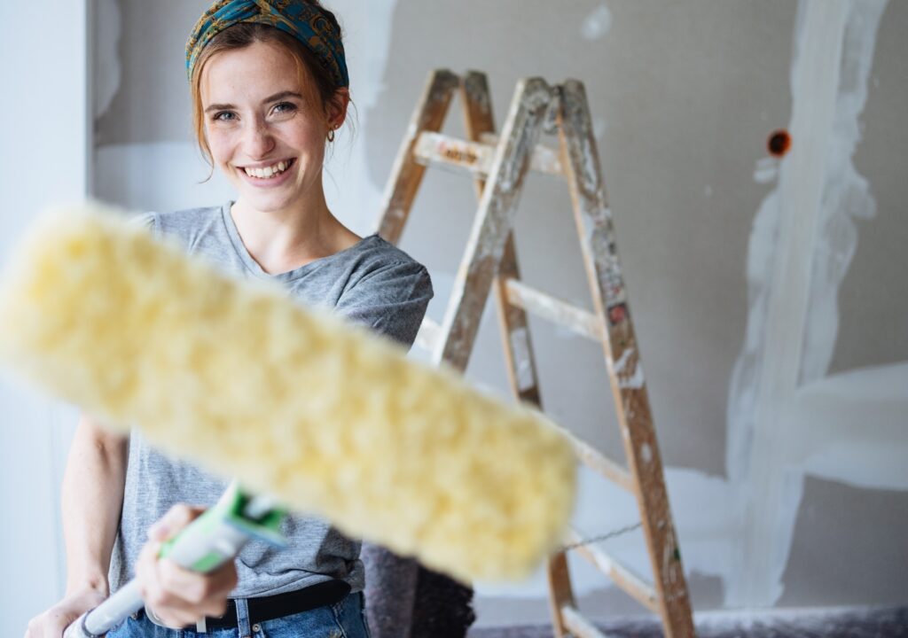woman decorating and painting her walls as a home improvement project